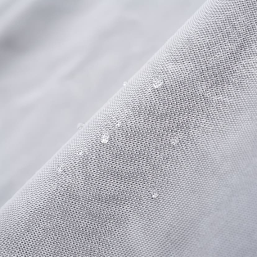 Close up of the light grey 420D Oxford polyester weave of a Weatherproof Lite cover, with a few water beads on it