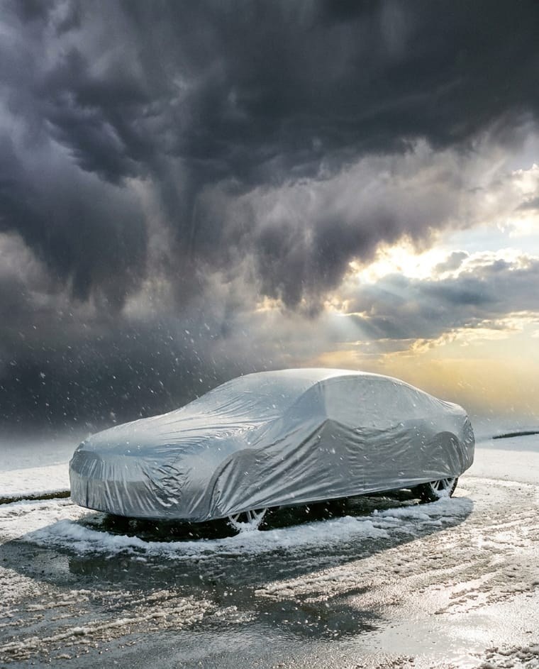 Silver cover on a sedan in a snow squall