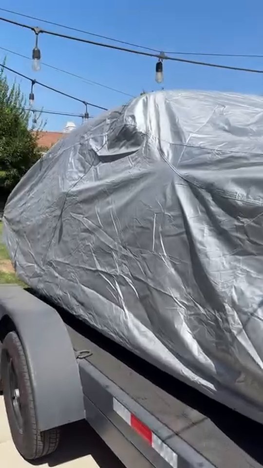 Silver Platinum cover fully on a seafoam 1962 Nova on a trailer in a driveway